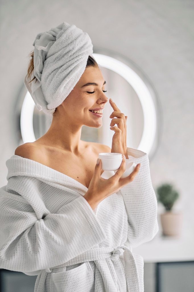 smiling woman who is doing skincare for herself